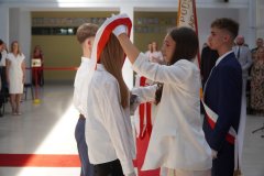 Członkowie pocztu sztandarowego przekazują sztandar reprezentantom klas siódmych i szóstych.