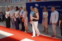 Na scenie stoją Rodzice uczniów klasy 8a nagrodzeni Listami Gratulacyjnymi.