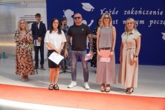 Na scenie stoją Rodzice uczniów klasy 8e nagrodzeni Listami Gratulacyjnymi.