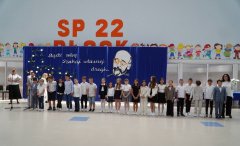 Na tle okolicznościowej dekoracji widać Uczniów klasy 3c po otrzymaniu nagród- pamiątek ukończenia I etapu edukacji. Towarzyszy Im Wychowawca- p. Iwona Kołodziejska.