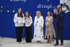 Na scenie stoją nagrodzone Uczennice klasy 8d z Panią Dyrektor, Przewodniczącym Rady Rodziców i Wychowawcą.