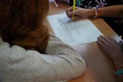 Grupa dziewcząt rozwiązujących krzyżówkę o Skłodowskiej.