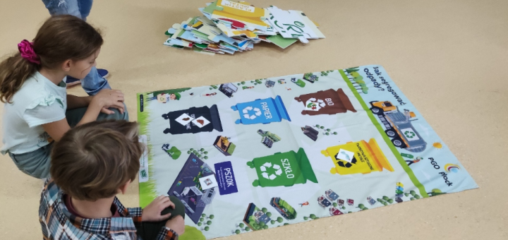Dzieci uczą się przy użyciu maty edukacyjnej, jak segregować odpady.