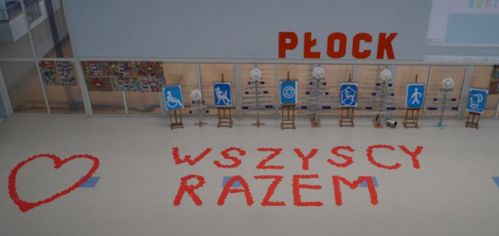 Sala gimnastyczna z napisem Wszyscy Razem oraz z ułożonym sercem.