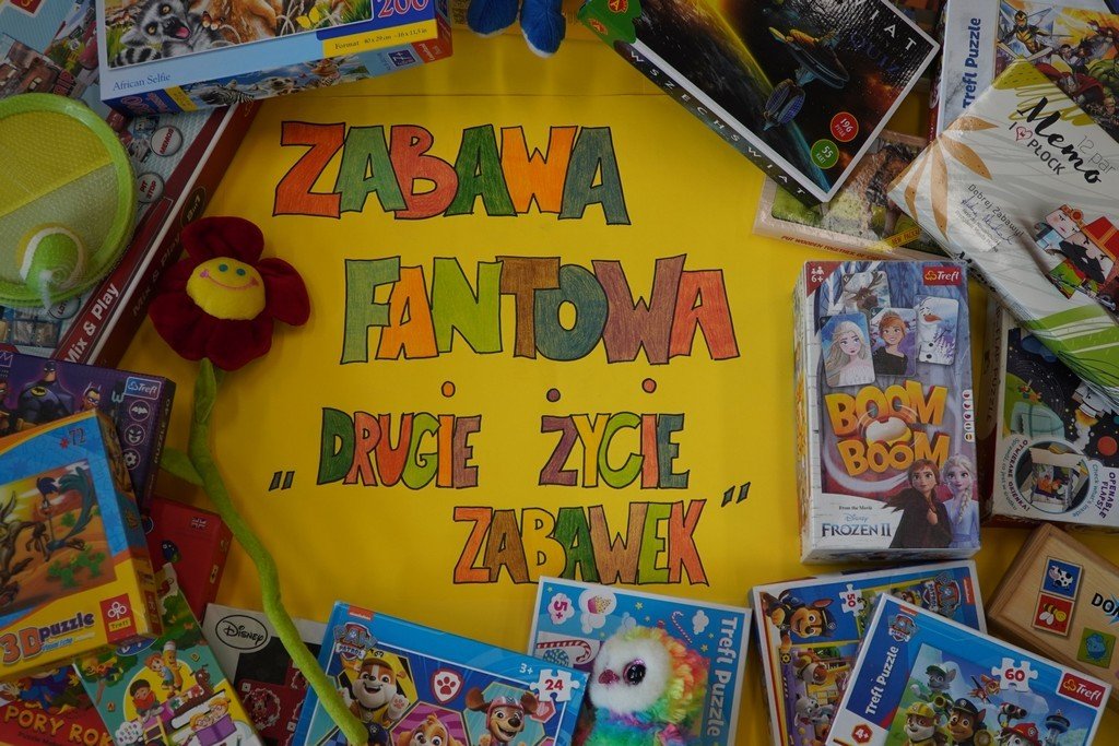 Na zdjęciu zamieszczony jest plakat. Jego żółte tło wypełnia wielobarwny napis „Zabawa fantowa- Drugie życie zabawek”. Wokół niego ułożone są różne zabawki, gry, puzzle...