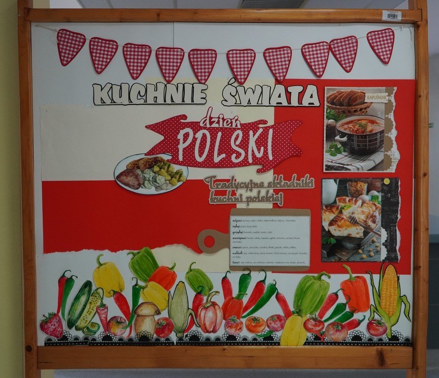Tablica informacyjna „Kuchnie świata – Dzień Polski” w biało-czerwonych barwach, ozdobiona zdjęciami tradycyjnych polskich potraw oraz ilustracjami warzyw i biało-czerwonych proporczyków.
