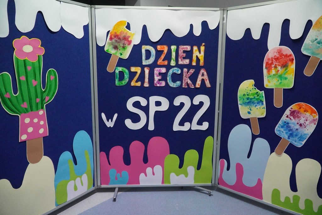 Zdjęcie dekoracji. Jest na niej napis "Dzień Dziecka w SP22" oraz tekturowe lody i kaktus.